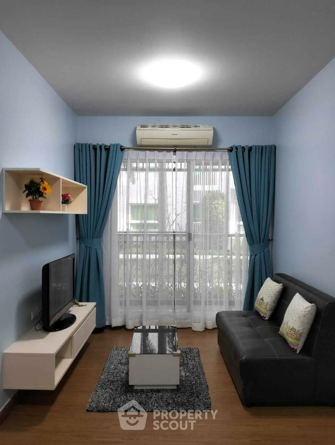 Cozy living room with modern decor, blue curtains, and natural light.
