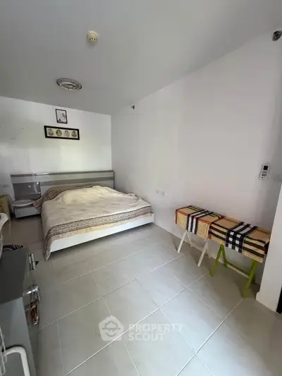 Spacious bedroom with modern decor and tiled flooring, perfect for comfort and relaxation.