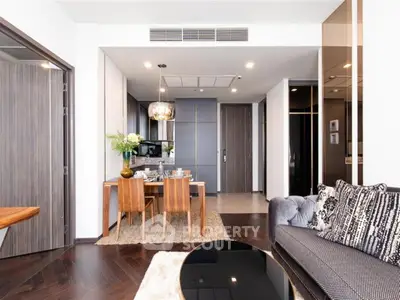 Modern open-plan living and dining area with stylish decor and hardwood floors in a luxury apartment.