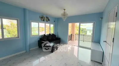 Spacious living room with elegant chandelier and balcony access