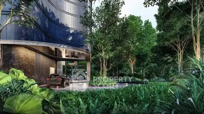 Luxurious modern building entrance surrounded by lush greenery and sleek architecture.