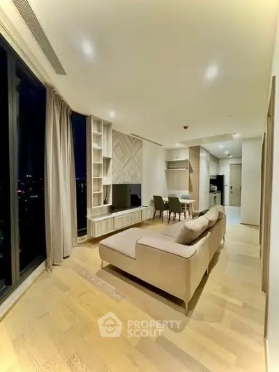 Modern living room with city view, stylish furniture, and open layout.