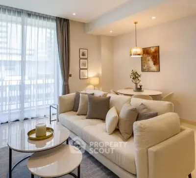 Elegant living room with modern decor, large windows, and cozy seating area in a stylish apartment.