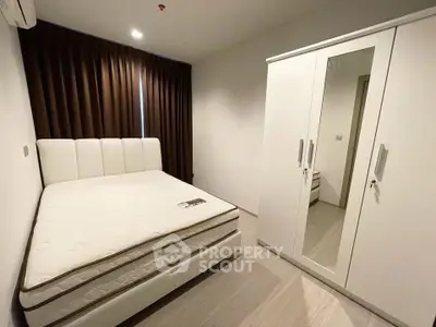 Modern bedroom with white wardrobe and comfortable bed in a cozy apartment.