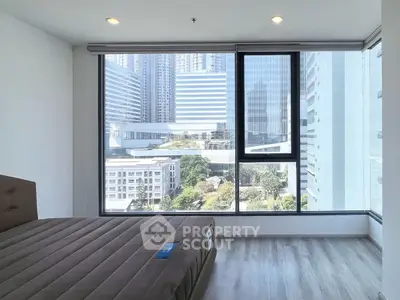 Modern bedroom with large windows offering stunning city views