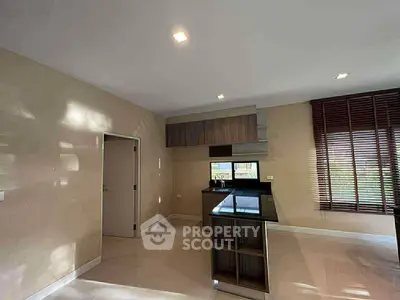 Modern kitchen with sleek design and open layout, featuring large windows and stylish cabinetry.
