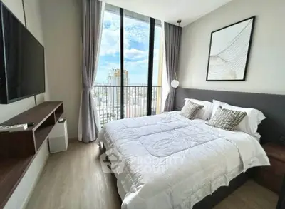 Modern bedroom with large window and city view, featuring stylish decor and natural light.