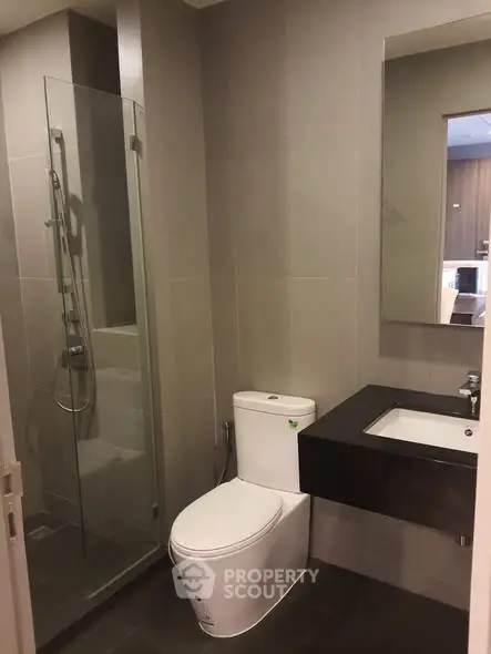 Modern bathroom with sleek design featuring glass shower and contemporary fixtures.