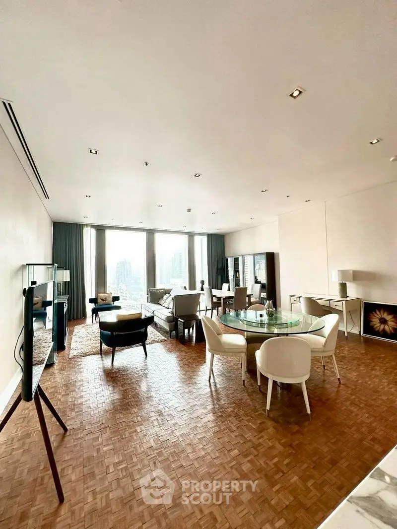 Spacious and elegant living room with parquet flooring and city view windows.