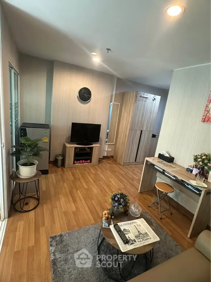 Modern living room with wooden flooring, stylish decor, and cozy seating area.