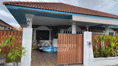 Charming single-story home with tiled roof and spacious front patio.