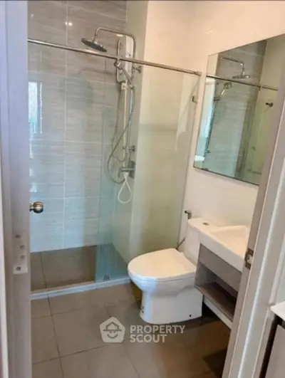 Modern bathroom with glass shower and sleek fixtures in a contemporary home.