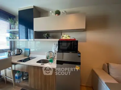 Modern kitchen with sleek appliances and stylish shelving in a cozy apartment setting.