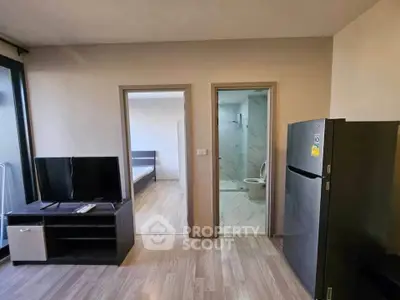 Modern apartment interior with open living area, visible bedroom, and bathroom, featuring sleek flooring and contemporary design.