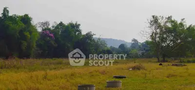 Expansive land plot with lush greenery and distant hills, perfect for development or investment opportunities.