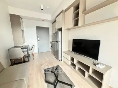 Modern living room with sleek furniture and built-in storage, featuring a flat-screen TV and stylish decor.