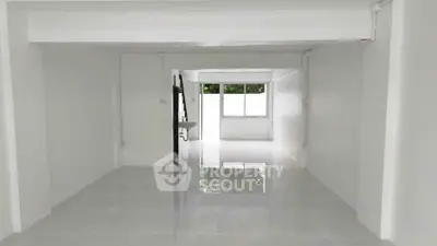 Spacious open-plan interior with glossy tiled floors and large windows for natural light.