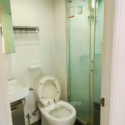 Compact bathroom with modern shower and toilet in a cozy apartment.