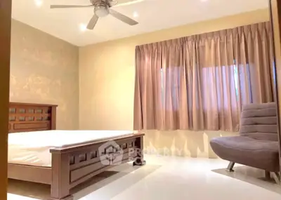 Spacious bedroom with elegant wooden bed and cozy seating area
