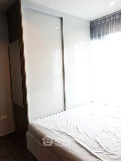 Modern bedroom with sleek wardrobe and natural light