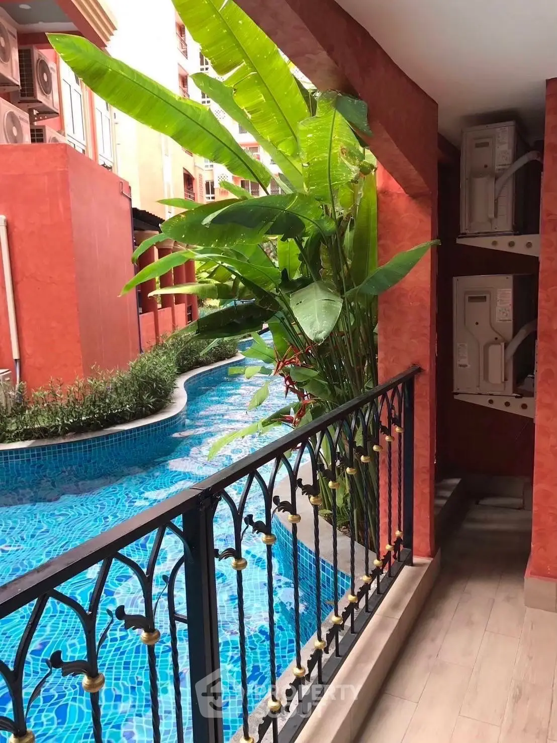 Stunning poolside view from a vibrant balcony with lush greenery.
