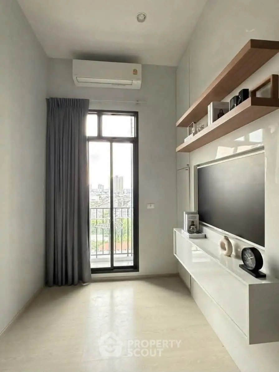 Modern living room with large window and sleek entertainment unit, offering a bright and airy atmosphere.
