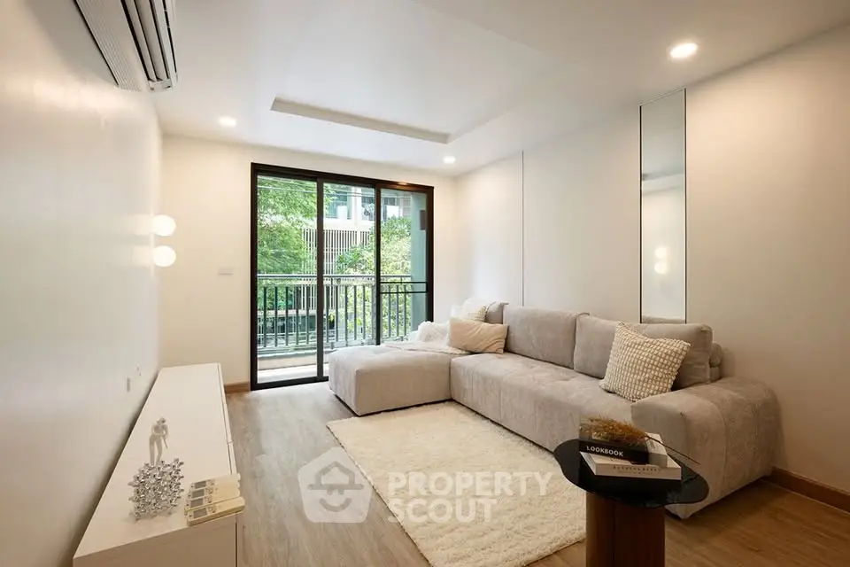Modern living room with cozy sofa and balcony view in a stylish apartment.