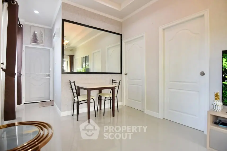 Modern interior with dining table and large mirror in a bright room.