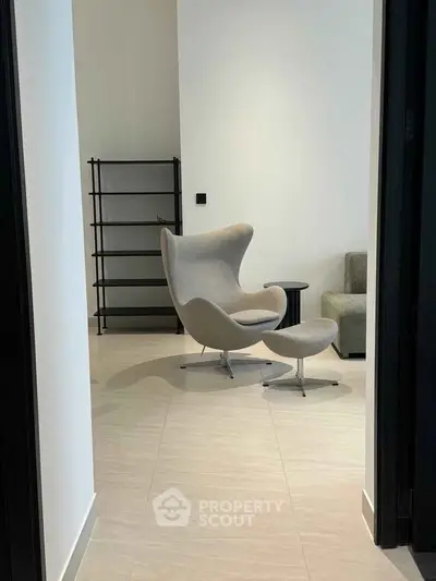 Modern minimalist interior with stylish chair and shelving unit in a bright room.