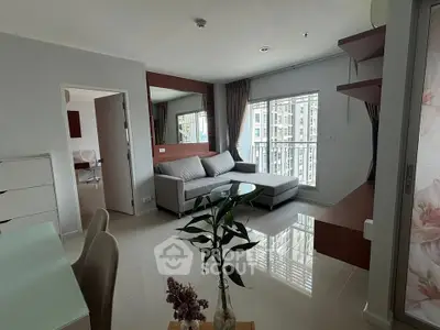 Modern living room with sleek furniture and large windows offering natural light.