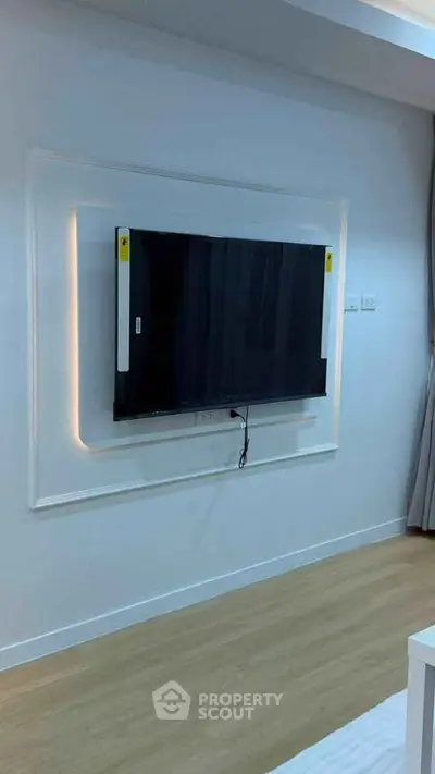 Modern living room with mounted flat-screen TV and elegant lighting.