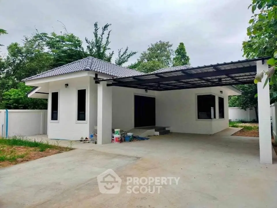 Charming single-story home with carport and lush greenery, perfect for serene living.