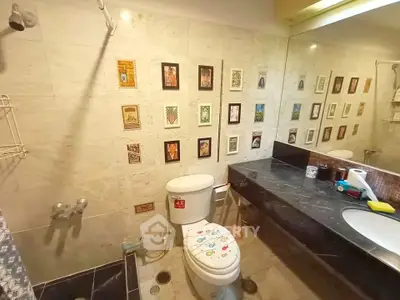 Charming bathroom with unique wall art and modern fixtures in a cozy home.