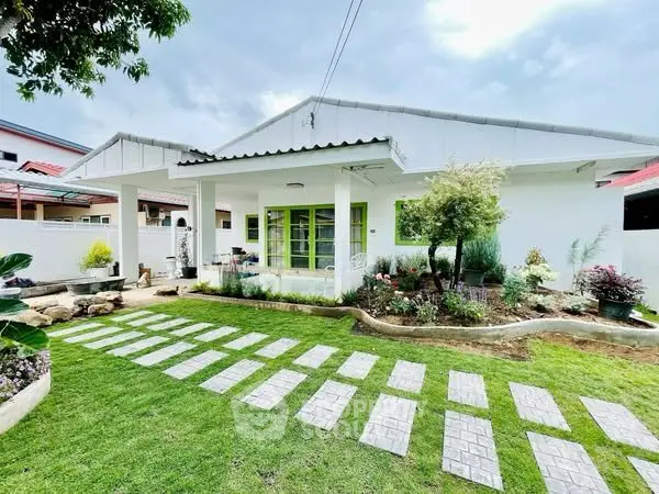 Charming single-story white house with lush garden and modern design