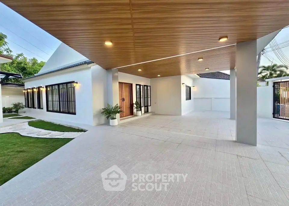 Modern single-story home with spacious covered driveway and elegant lighting