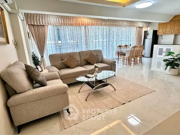 Spacious living room with elegant decor and large windows offering natural light.