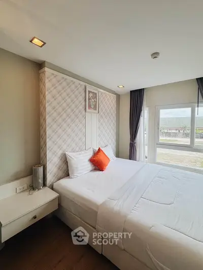Spacious bedroom with large windows and modern decor in a luxury apartment.