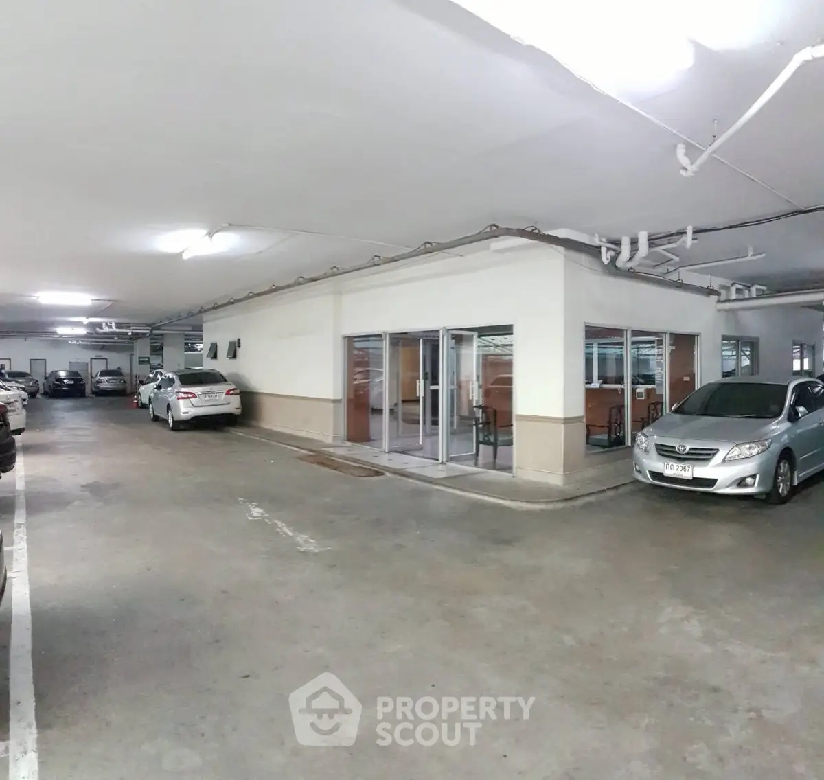 Spacious underground parking area with multiple cars and secure entry.