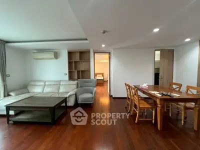 Spacious living room with wooden flooring and modern furniture in a stylish apartment.