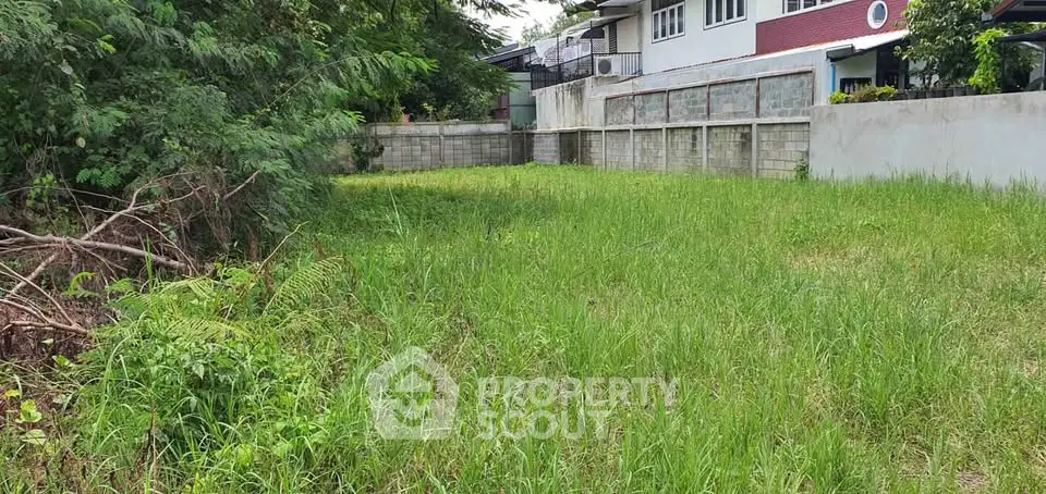 Spacious residential plot with lush greenery and boundary walls, ideal for building a dream home.