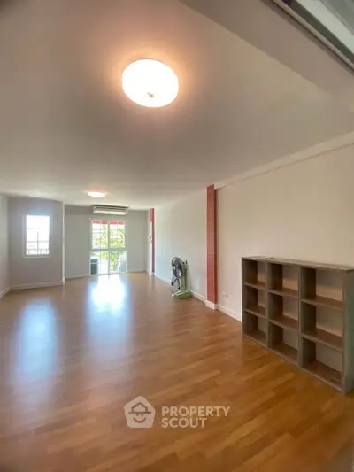 Spacious living room with wooden flooring and ample natural light