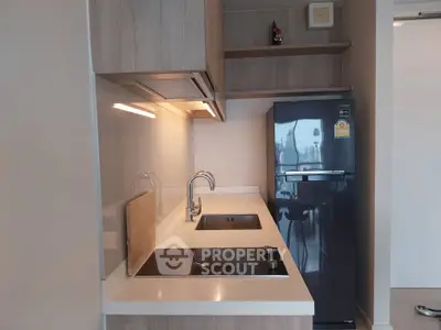 Modern kitchen with sleek appliances and stylish cabinetry in a contemporary apartment.
