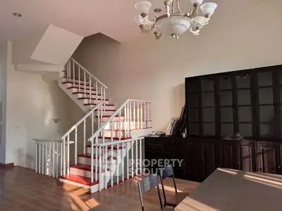 Spacious living room with elegant staircase and natural light