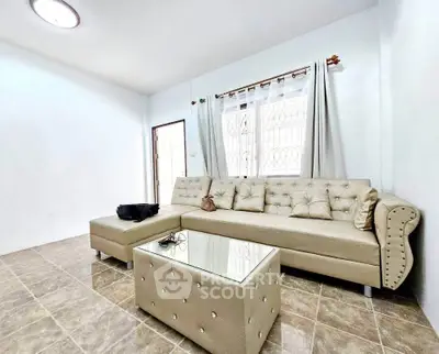 Spacious living room with elegant beige sofa and glass coffee table, perfect for relaxation and entertaining.
