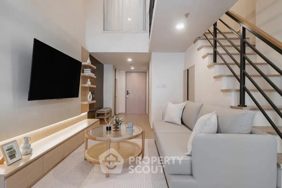 Modern living room with stylish decor and open staircase, perfect for contemporary living.