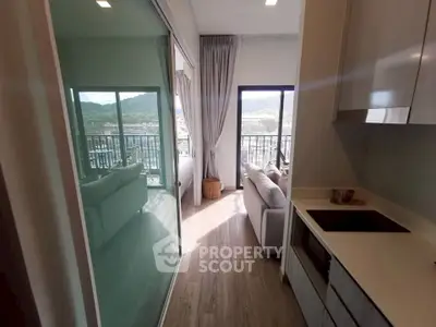 Modern apartment with open kitchen and balcony offering stunning mountain views.