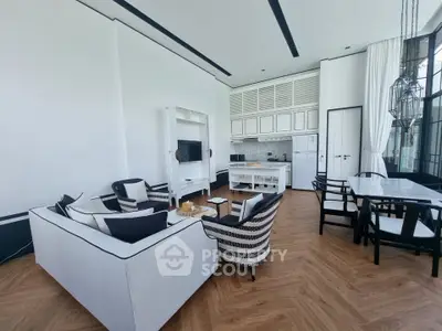 Luxurious open-plan living room with elegant decor and modern kitchen in a high-end apartment.