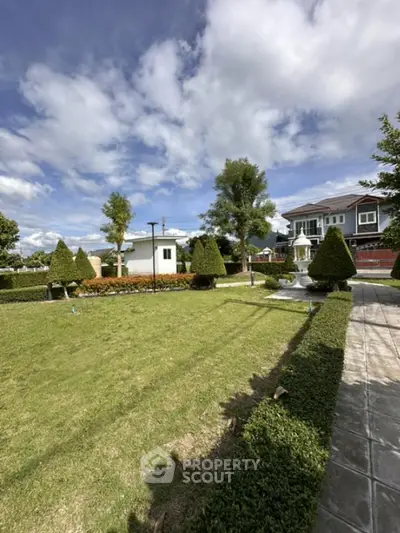 Spacious garden with manicured hedges and a charming fountain in a residential property