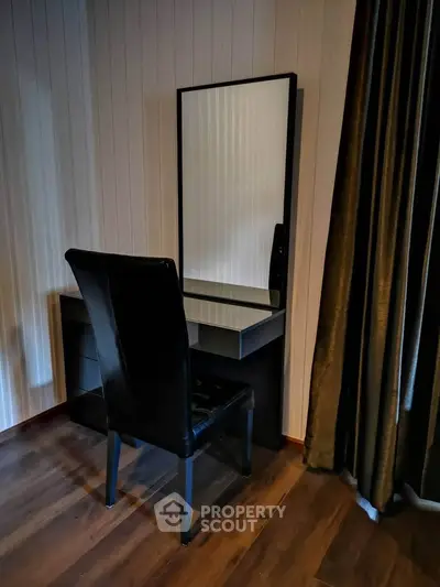 Elegant bedroom corner with stylish black vanity and chair, perfect for modern interiors.