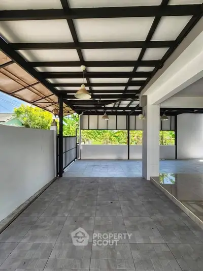 Spacious covered patio with modern design and tiled flooring, perfect for outdoor gatherings.